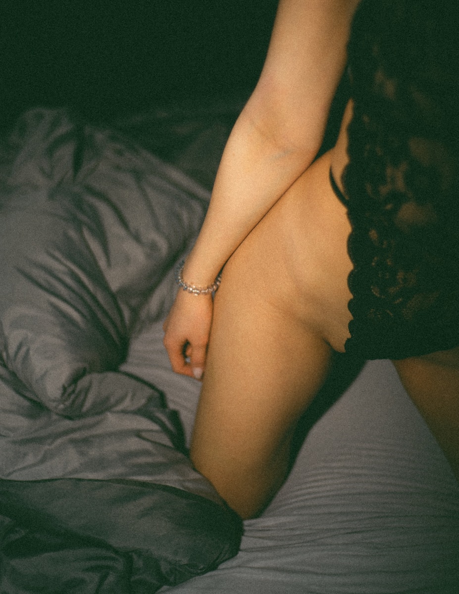 Photo by BĀBI a naked woman sitting on top of a bed